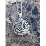 Pendentif Triquetra Lune argent 925 posé sur roche naturelle, motif ajouré celtique aux reflets argentés.