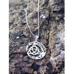 Gros plan sur pendentif Triquetra Lune argent 925 posé sur roche, croissant ajouré et chaîne argentée.