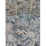 Collier doré Onyx pierres naturelles sur décor clair, détails noirs et dorés pour un rendu élégant, profond et raffiné.