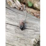 Gros plan sur pendentif pointe Rhodonite avec chaîne acier inoxydable, pierre polie rose et noire pour tendresse et recentrage.