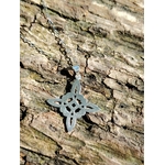 Pendentif Nœud de Sorcière en argent 925 posé sur écorce en lumière naturelle, bijou fin au motif entrelacé.