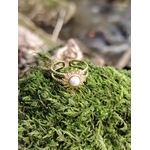 Bague dorée Soleil posée dans la mousse bretonne, anneau ajustable et cabochon blanc au style bohème lumineux.