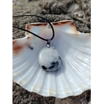 Pendentif Péristérite sur cordon noir posé dans une coquille blanche, pierre nacrée aux inclusions sombres en décor marin breton.