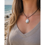 Pendentif Péristérite porté au cou avec mer de Bretagne en arrière-plan, bijou lunaire pour apaisement émotionnel.