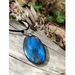 Gros plan sur pendentif Labradorite naturelle aux éclats bleu électrique, posé sur bois brut avec mousse, bijou minéral au charme mystérieux.