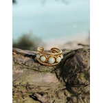 Bague dorée réglable multi Amazonite posée sur bois avec arrière-plan marin flou, cabochons bleu-vert pour apaisement et élégance.
