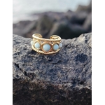 Bague dorée multi Amazonite posée sur roche près de la mer, cabochons lumineux et monture ajourée pour calme et style solaire.