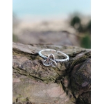 Bague Triquetra Argent 925 ajustable posée sur bois naturel, symbole celtique argenté avec arrière-plan marin flou pour harmonie et protection.