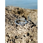 Bague ajustable Triquetra en argent posée sur roche coquillée au bord de mer, bijou symbolique lié à l’harmonie et au lien intérieur.