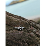 Bague Triquetra Argent 925 sur bois face à la mer, motif entrelacé fin et anneau travaillé pour un style celtique discret.