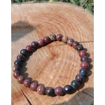 Bracelet Jaspe Polychrome sur rondin de bois au soleil, perles naturelles rouge brun, beige et noir, pour présence, courage et enracinement.