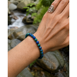 Bracelet Azurite-Malachite 6 mm porté avec bague Triskell, décor de ruisseau, protection et vision intérieure.