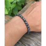 Bracelet Larvikite 8 mm porté au poignet sur fond clair, perles sombres naturelles, stabilité émotionnelle et patience.