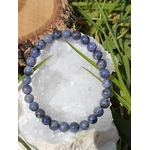 Bracelet Tanzanite sur cristal blanc et herbe verte, perles violet bleuté pour méditation, clairvoyance et éveil intérieur.