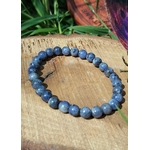 Bracelet Tanzanite 6-7 mm sur tranche de bois avec herbe, bijou en perles naturelles pour confiance en soi et créativité.