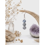 Boucle d’oreille Labradorite Magic Gaïa suspendue sur bois flotté, fleurs séchées, améthyste floue et clarté.