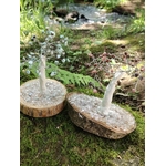 Duo d’arbres Magic Gaïa en rhodonite et pierres bleu pâle sur rondins de bois, décor forestier avec fougères et ruisseau.