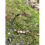 Bracelet réglable avec breloque étoile dorée, perles facettées chaleureuses et cordon noir noué pour un style céleste discret.