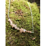 Collier pierre de soleil création Magic Gaïa en situation naturelle, pierres pêche lumineuses sur chaîne acier, énergie solaire et confiance.