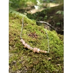 Collier pierre de soleil création Magic Gaïa posé sur mousse en forêt, pierres pêche rosées et chaîne acier inoxydable.