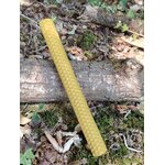 Bougie artisanale en cire d’abeille posée en diagonale sur un tronc, décor naturel pour méditation et moment de calme