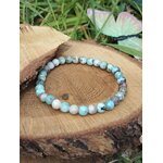 Bracelet larimar en perles naturelles sur rondin de bois avec papillon décoratif, bleu des Caraïbes et douceur émotionnelle