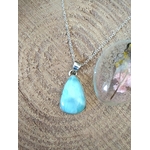 Pendentif larimar bleu monté en argent 925 sur fond bois naturel avec résine fleurie, bijou en pierre naturelle évoquant la douceur, la sérénité et la fluidité intérieure.