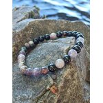 Bracelet tourmaline multicolore 6 mm sur rocher près de l’eau, bijou en pierre naturelle pour ancrage profond et sécurité énergétique