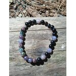Bracelet tourmaline multicolore 6 mm sur planche de bois en extérieur, perles naturelles violet, vert et noir pour protection et stabilité intérieure
