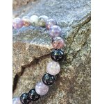 Gros plan bracelet tourmaline multicolore 6 mm sur rocher, nuances naturelles et reflets variés pour équilibre émotionnel et enracinement