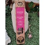 Boîte d’encens organique « Descarga Total / Total Discharge » (smudge sticks) pour rituel de purification, posée sur gazon, adossée à une sélénite, avec une petite décoration rose à côté — packaging rose/beige, fond naturel.