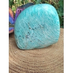 Amazonite polie posée sur plateau en bois rainuré, nuances lagon et détails minéraux mis en valeur en Bretagne.