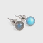 Puces / clous d’oreilles en labradorite bleue, cabochons ronds 6 mm, acier inox 304, reflets bleutés — fond blanc.