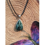 Pendentif goutte en séraphinite posé sur tranche de bois avec décor violet, reflet fibreux et monture argent 925, pierre naturelle associée à la sérénité, au relâchement et à l’équilibre intérieur.