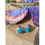 Boucles d’oreilles apatite bleue cabochons ronds en argent 925, posées sur planche de bois avec papillon décoratif à côté — stimule la créativité et l’inspiration.