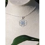 Pendentif graine de vie en argent 925 sur buste mannequin avec chaîne fine et feuille verte au premier plan