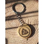 Porte-clés bois rond, triquetra gravé entouré de phases lunaires, anneau métal visible sur rondin