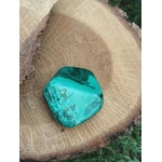Pierre naturelle malachite à bandes concentriques sur bois ; décor extérieur herbe — transmutation des énergies, clarté émotionnelle