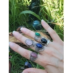 Main ornée de bagues artisanales en argent sterling 925 : cabochons de Malachite, Quartz Rose, Lapis-Lazuli, Rhodonite et Onyx, style filigrané, décor végétal