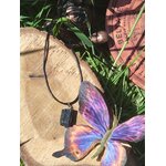 Tourmaline noire brute en pendentif posée sur bois avec papillon illustré et feuillage, bijou en pierre naturelle associé à la protection, au calme du mental et à la présence à soi.