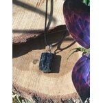Pendentif tourmaline noire brute sur bois naturel, bijou en pierre naturelle associé à l’ancrage, à la stabilité intérieure et à la protection subtile.