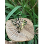 Bague nœud de sorcière réglable en acier inox sur champignon, herbes en arrière-plan