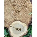 Set bijou Triple Lune doré avec pendentif et bracelet, acier inoxydable sur fond bois et feuillage, esprit mystique