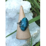 Bague apatite bleue réglable en argent 925 sur cône en bois, devant un amas de quartz — communication, clarté mentale, équilibre émotionnel.