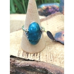 Bague apatite bleue réglable en argent 925 sur cône bois, posée sur rondin ; papillon flou à droite — communication, clarté mentale, équilibre émotionnel
