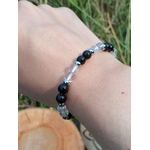Bracelet énergie négative porté au poignet en extérieur, perles noires et cristal de roche pour se préserver des influences lourdes et garder son axe