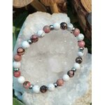 Bracelet howlite veinée et rhodonite rose posé sur géode, libération émotionnelle et réconciliation avec l’enfant intérieur