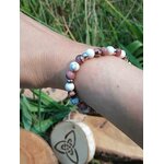 Bracelet déblocages émotionnels howlite et rhodonite porté au poignet, décor nature, apaisement du ressenti et sérénité relationnelle