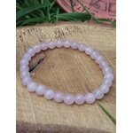 Bracelet quartz rose 6 mm posé sur support en bois, délicatesse émotionnelle, harmonie du cœur et sérénité affective