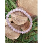 Bracelet quartz rose en perles rondes sur champignons décoratifs dans l’herbe, bienveillance, sensibilité apaisée et tendresse relationnelle